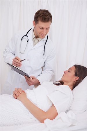 simsearch:400-05748252,k - Doctor standing next to bedridden patient Stock Photo - Budget Royalty-Free & Subscription, Code: 400-05748252