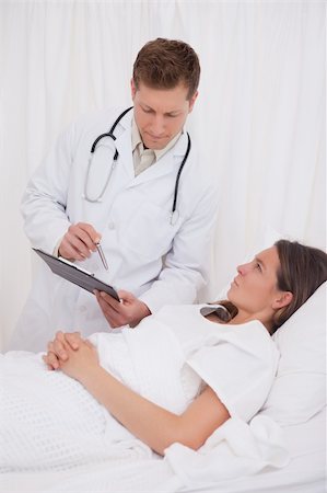 simsearch:400-05748252,k - Standing doctor talking with bedridden patient Stock Photo - Budget Royalty-Free & Subscription, Code: 400-05748253