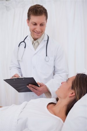 simsearch:400-05748252,k - Doctor with clipboard talking with bedridden patient Stock Photo - Budget Royalty-Free & Subscription, Code: 400-05748265