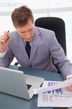 simsearch:400-05748170,k - Businessman with statistics sitting at his desk Stock Photo - Budget Royalty-Free & Subscription, Code: 400-05748279