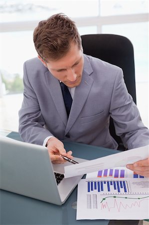 simsearch:400-05748170,k - Businessman at his desk looking at statistics Stock Photo - Budget Royalty-Free & Subscription, Code: 400-05748280