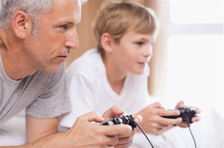 simsearch:400-05751526,k - Father playing video games with his son in a bedroom Stock Photo - Budget Royalty-Free & Subscription, Code: 400-05749394