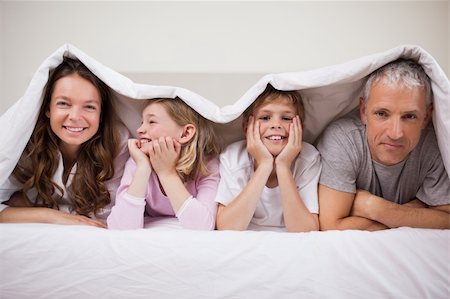 simsearch:400-05749633,k - Happy family lying under a duvet in a bedroom Stock Photo - Budget Royalty-Free & Subscription, Code: 400-05749439