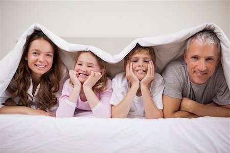 simsearch:400-05749633,k - Playful family lying under a duvet in a bedroom Stock Photo - Budget Royalty-Free & Subscription, Code: 400-05749440