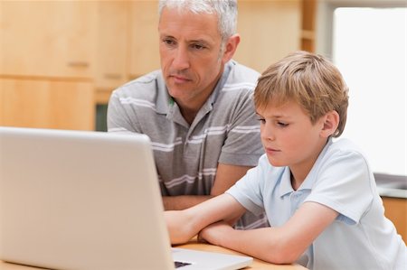 simsearch:400-05751173,k - Boy and his father using a laptop in a kitchen Stock Photo - Budget Royalty-Free & Subscription, Code: 400-05749510