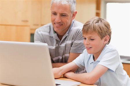 simsearch:400-05749727,k - Boy and his father using a notebook in their kitchen Foto de stock - Super Valor sin royalties y Suscripción, Código: 400-05749511