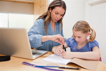 simsearch:400-05749563,k - Woman helping her daughter doing her homework in a kitchen Stock Photo - Budget Royalty-Free & Subscription, Code: 400-05749556