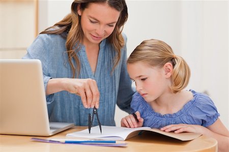 simsearch:400-05749563,k - Mother helping her daughter doing her homework in a kitchen Stock Photo - Budget Royalty-Free & Subscription, Code: 400-05749557