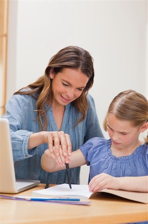 simsearch:400-05749563,k - Portrait of a mother helping her daughter doing her homework in a kitchen Stock Photo - Budget Royalty-Free & Subscription, Code: 400-05749558