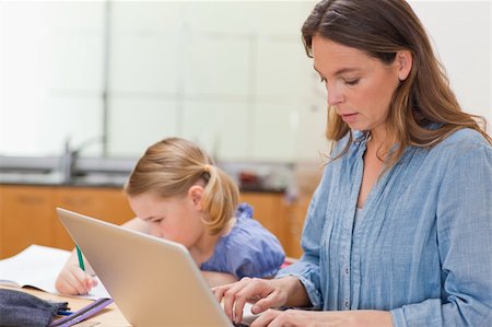 simsearch:400-05749727,k - Little girl doing her homework while her mother is using laptop in a kitchen Foto de stock - Super Valor sin royalties y Suscripción, Código: 400-05749565