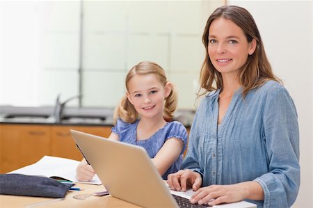 simsearch:400-05749563,k - Girl doing her homework while her mother is working with laptop in a kitchen Stock Photo - Budget Royalty-Free & Subscription, Code: 400-05749566