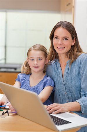 simsearch:400-05749563,k - Portrait of a girl doing her homework while her mother is working with laptop in a kitchen Stock Photo - Budget Royalty-Free & Subscription, Code: 400-05749567
