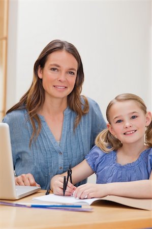 simsearch:400-05749563,k - Portrait of a beautiful woman helping her daughter doing her homework in a kitchen Stock Photo - Budget Royalty-Free & Subscription, Code: 400-05749560