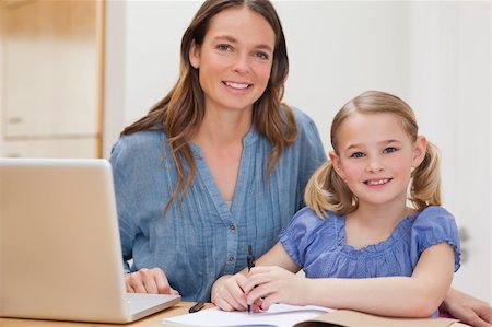 simsearch:400-05749563,k - Beautiful woman helping her daughter doing her homework in a kitchen Stock Photo - Budget Royalty-Free & Subscription, Code: 400-05749561