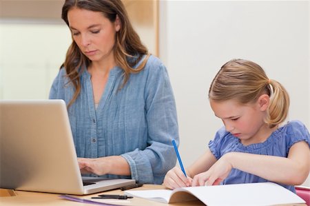 simsearch:400-05749563,k - Girl doing her homework while her mother is using laptop in a kitchen Stock Photo - Budget Royalty-Free & Subscription, Code: 400-05749562