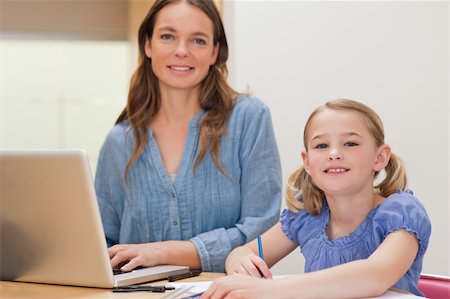 simsearch:400-05749563,k - Girl doing her homework while her mother is using notebook in a kitchen Stock Photo - Budget Royalty-Free & Subscription, Code: 400-05749563