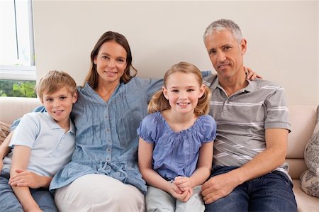 simsearch:400-05749633,k - Happy family sitting on a sofa looking at the camera Stock Photo - Budget Royalty-Free & Subscription, Code: 400-05749594