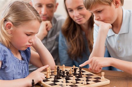 simsearch:400-05749633,k - Close up of children playing chess in front of their parents in a living room Stock Photo - Budget Royalty-Free & Subscription, Code: 400-05749618