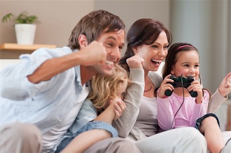 simsearch:400-05749633,k - Positive family playing video games together in a living room Stock Photo - Budget Royalty-Free & Subscription, Code: 400-05749664