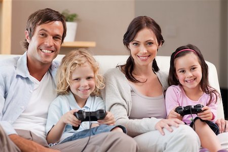 simsearch:400-05749633,k - Smiling family playing video games together in a living room Stock Photo - Budget Royalty-Free & Subscription, Code: 400-05749665