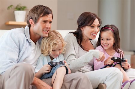 simsearch:400-05749633,k - Competitive family playing video games together in a living room Stock Photo - Budget Royalty-Free & Subscription, Code: 400-05749666