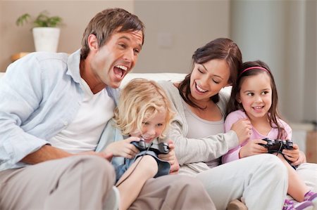 simsearch:400-05749633,k - Laughing family playing video games in a living room Stock Photo - Budget Royalty-Free & Subscription, Code: 400-05749668