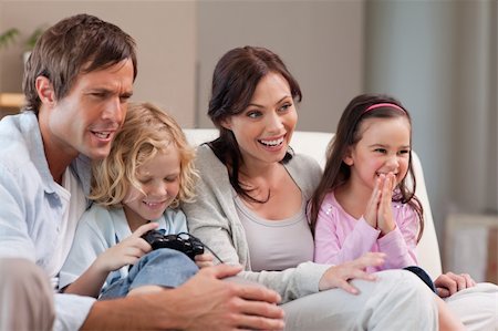 simsearch:400-05749633,k - Happy family playing video games together in a living room Stock Photo - Budget Royalty-Free & Subscription, Code: 400-05749661