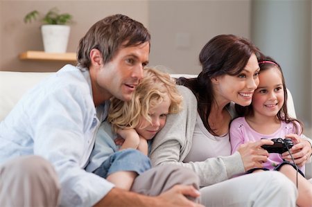 simsearch:400-05749633,k - Playful family playing video games together in a living room Stock Photo - Budget Royalty-Free & Subscription, Code: 400-05749662