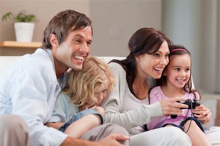 simsearch:400-05749633,k - Delighted family playing video games together in a living room Stock Photo - Budget Royalty-Free & Subscription, Code: 400-05749663
