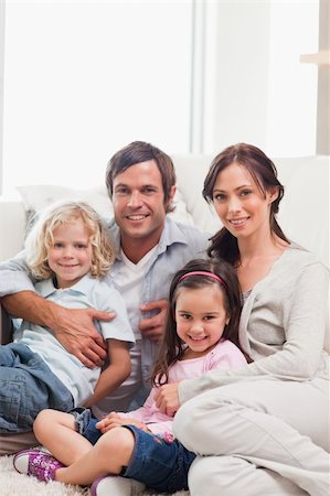 simsearch:400-04193348,k - Portrait of a family relaxing on a sofa while looking at the camera Stock Photo - Budget Royalty-Free & Subscription, Code: 400-05749699
