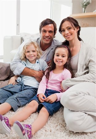 simsearch:400-04193348,k - Portrait of a family relaxing in their living room while looking at the camera Stock Photo - Budget Royalty-Free & Subscription, Code: 400-05749701