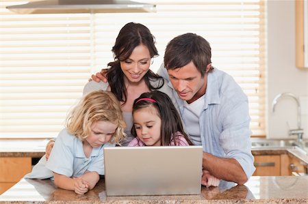 simsearch:400-05751173,k - Family using a notebook together in a kitchen Stock Photo - Budget Royalty-Free & Subscription, Code: 400-05749714