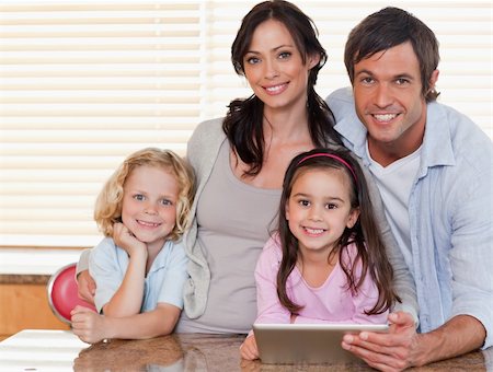 simsearch:400-05749727,k - Smiling family using a tablet computer together in a kitchen Foto de stock - Super Valor sin royalties y Suscripción, Código: 400-05749719