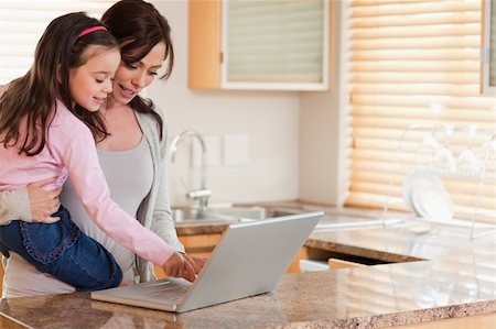 simsearch:400-05751173,k - Girl and her mother using a laptop in a kitchen Stock Photo - Budget Royalty-Free & Subscription, Code: 400-05749726