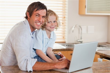 simsearch:400-05751173,k - Boy and his father using a notebook together in a kitchen Stock Photo - Budget Royalty-Free & Subscription, Code: 400-05749722