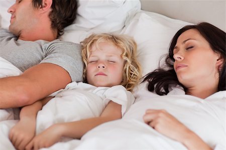 simsearch:640-06963757,k - Boy sleeping between his parents in a bedroom Stock Photo - Budget Royalty-Free & Subscription, Code: 400-05749812