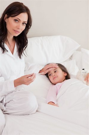 simsearch:632-03424324,k - Portrait of a concerned mother checking on her daughter's temperature in a bedroom Stock Photo - Budget Royalty-Free & Subscription, Code: 400-05749824