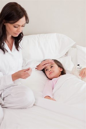 simsearch:632-03424324,k - Portrait of a mother checking on her daughter's temperature in a bedroom Stock Photo - Budget Royalty-Free & Subscription, Code: 400-05749823