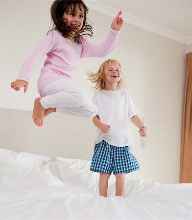 Portrait of playful siblings jumping on a bed Stock Photo - Budget Royalty-Free & Subscription, Code: 400-05749837