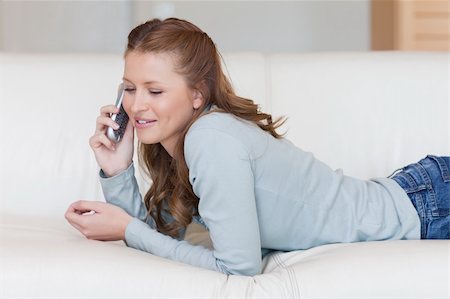 simsearch:400-05716397,k - Young smiling female phoning on the couch Photographie de stock - Aubaine LD & Abonnement, Code: 400-05740766