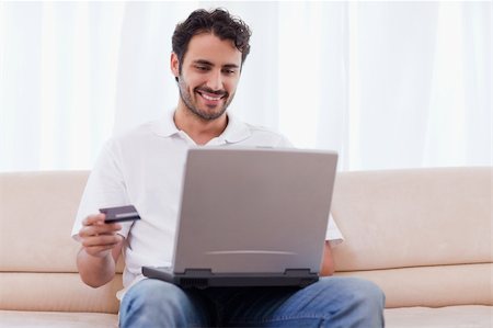 face to internet technology - Man buying online in his living room Photographie de stock - Aubaine LD & Abonnement, Code: 400-05741527