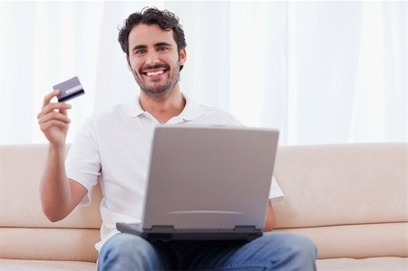 face to internet technology - Happy man buying online in his living room Photographie de stock - Aubaine LD & Abonnement, Code: 400-05741529