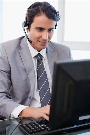 Portrait of a happy sales assistant working with a monitor in his office Stock Photo - Budget Royalty-Free & Subscription, Code: 400-05741959