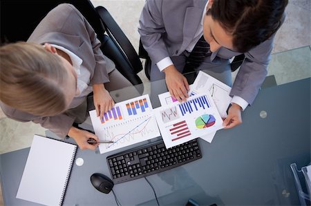 simsearch:400-05710386,k - Business team looking at statistics in a meeting room Stock Photo - Budget Royalty-Free & Subscription, Code: 400-05741968