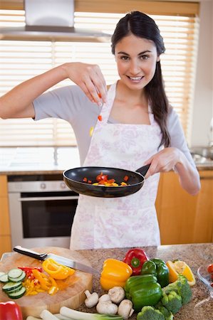 simsearch:400-05744780,k - Portrait of a woman preparing a dish in her kitchen Stock Photo - Budget Royalty-Free & Subscription, Code: 400-05742647