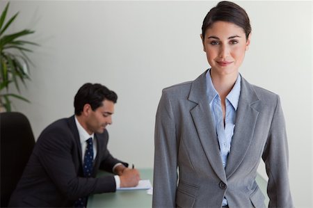 simsearch:400-05746962,k - Beautiful businesswoman posing while her colleague is working in an office Stock Photo - Budget Royalty-Free & Subscription, Code: 400-05742794