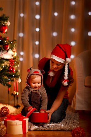 Young mother with happy baby opening present box near Christmas tree Stock Photo - Budget Royalty-Free & Subscription, Code: 400-05743917