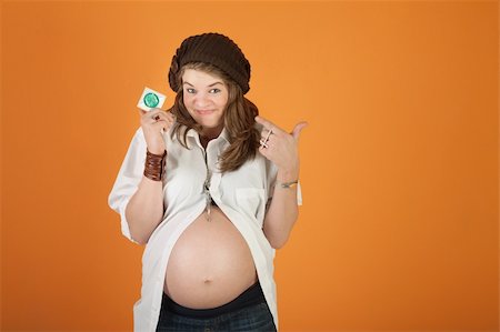 female condom - Smiling pregnant woman over orange background points at a condom Stock Photo - Budget Royalty-Free & Subscription, Code: 400-05755774