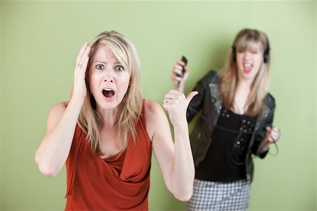 simsearch:400-05918419,k - Annoyed mom with daughter listening on headphones Stock Photo - Budget Royalty-Free & Subscription, Code: 400-05755786