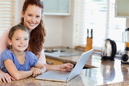 simsearch:400-05751173,k - Mother and daughter surfing the internet together in the kitchen Stock Photo - Budget Royalty-Free & Subscription, Code: 400-05751175